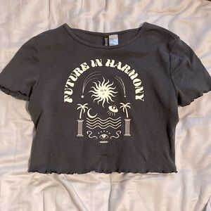 Cute grey crop top with pastel yellow image and writing “future in harmony”.